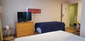 1 dormitorio con cama y vestidor con TV en (2310)Flat Ibirapuera special (Apt. particular), en São Paulo