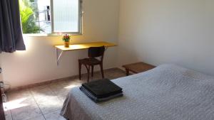 - une chambre avec un lit, une table et un bureau dans l'établissement Casa 48 Guesthouse, à Rio de Janeiro
