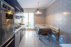 eine Küche mit einem Tisch und einer Arbeitsplatte in der Unterkunft Elegante appartamento di 200 mq con vista a Sanremo in Sanremo