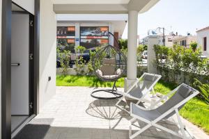 un porche con 2 sillas y un columpio en Cozy Corner Luxury Apartments en La Canea