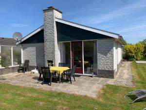 a patio with a yellow table and chairs at Bungalow36 - Petten in Petten