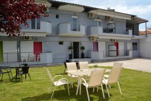 a table and chairs in front of a house at Gatos Village Studios & Apartments in Asprovalta