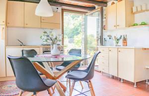 uma cozinha com uma mesa de vidro e cadeiras em Solivo Farm em Cannobio