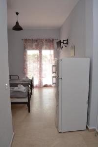 a kitchen with a refrigerator and a room with beds at Gatos Village Studios & Apartments in Asprovalta