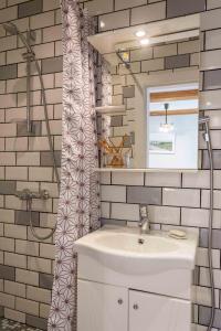 a bathroom with a sink and a mirror at Cozy one room apartment with yard in Juodkrantė