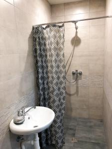 a bathroom with a shower curtain and a sink at Marsas in Zarasai