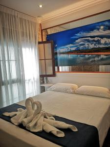 sypialnia z łóżkiem z ręcznikami w obiekcie Hostal Costa De La Luz w mieście Conil de la Frontera