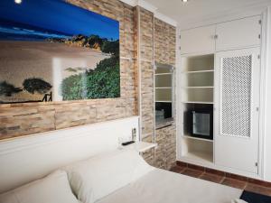 a bedroom with a bed and a large painting on the wall at Hostal Costa De La Luz in Conil de la Frontera