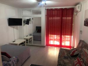 ベナルマデナにあるEstudio Agata 340のリビングルーム(ベッド1台、赤いカーテン付)