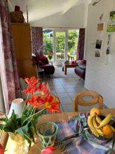 a table with a bowl of fruit and flowers on it at Bungalow36 - Petten in Petten +2 photos