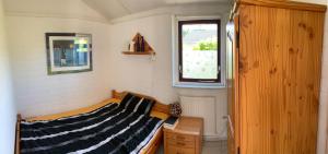 a small room with a bed and a window at Bungalow36 - Petten in Petten