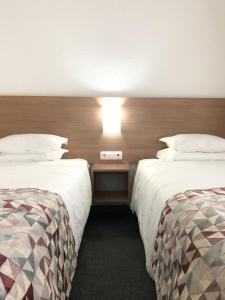 a hotel room with two beds and a light on the wall at Hotel Flamingo in Lisbon