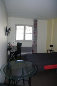 1 dormitorio con 1 cama, mesa de cristal y escritorio en Résidence d'Artagnan, en Montargis