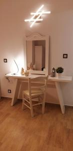 a table with a chair and a mirror in a room at Katerina Apartments & Studios in Naousa