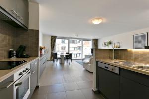 a large kitchen with a living room and a table at Lichtrijk appartement Oostende in Ostend