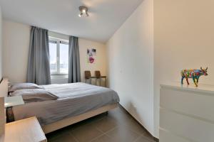 מיטה או מיטות בחדר ב-Lichtrijk appartement Oostende