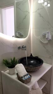 a bathroom with a black sink and a mirror at Katerina Apartments & Studios in Naousa