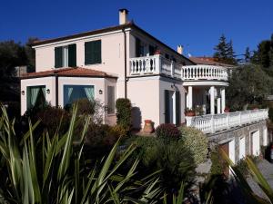une grande maison blanche avec une clôture blanche dans l'établissement B&B Villa Isabella, à Imperia