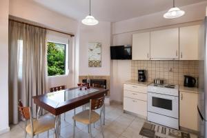 a kitchen with a table and chairs in a kitchen at Villa Nektaria in Nikiana