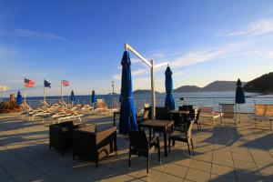 a group of tables and chairs with blue umbrellas at Hotel San Terenzo in Lerici