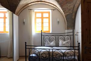 een slaapkamer met een zwart bed in een kamer met ramen bij Ferienwohnung Toscana am Berzdorfer See in Jauernick-Buschbach