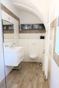 een badkamer met een witte wastafel en een toilet bij Ferienwohnung Toscana am Berzdorfer See in Jauernick-Buschbach