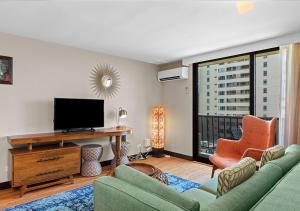 a living room filled with furniture and a tv at Castle Bamboo Waikiki Hotel in Honolulu