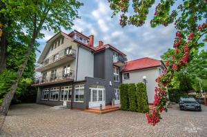 Außenansicht eines Hauses mit Einfahrt in der Unterkunft Villa Chrobry in Mielno