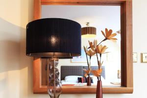 una lámpara sentada en una mesa frente a un espejo en O'Donnabhain's en Kenmare