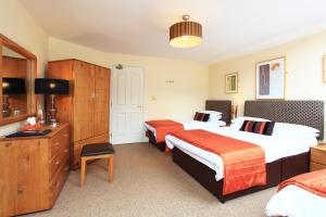 Habitación de hotel con 2 camas y escritorio en O'Donnabhain's, en Kenmare