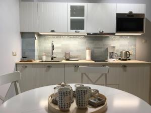 a kitchen with a table with two mugs on it at Apartament Silence Baltic Lazur in Pobierowo