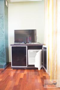 a flat screen tv sitting on top of a entertainment center at HOLIDAYS MIRANA in Yecla