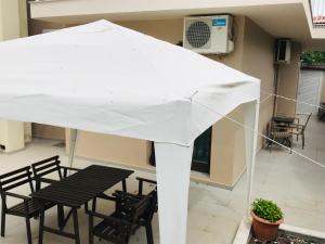 a white umbrella on a patio with chairs and a table at Melidron in Nea Roda