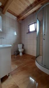 a bathroom with a toilet and a sink and a window at Domki Marina Niedźwiedzi Róg in Ruciane-Nida