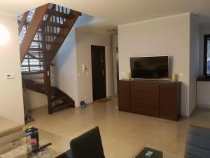 a living room with a television and a staircase at Dwie Mewy in Pobierowo