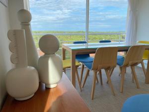 una sala da pranzo con tavolo, sedie e finestra di Vue superbe sur l’océan, la plage à vos pieds ! a Soorts-Hossegor