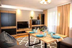 uma sala de estar com uma mesa e uma televisão em Apartament Panorama 2 18 em Polańczyk