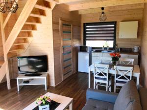 a living room with a couch and a kitchen and a table at White Houses Rewal in Rewal