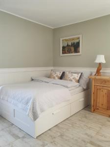 biała sypialnia z białym łóżkiem i stołem w obiekcie Apartament Ohar w Sztutowie