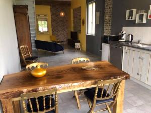 Il comprend une cuisine et une salle à manger avec une table et des chaises en bois. dans l'établissement Domaine Saint Esselin, à Larreule