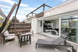a balcony with chairs and a table on a house at Village Naturiste - La Villa Tentation Port Nature Luxe in Cap d'Agde