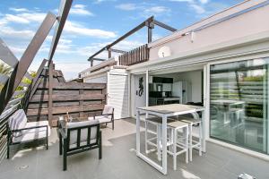 a balcony with a table and chairs on a house at Village Naturiste - La Villa Tentation Port Nature Luxe in Cap d'Agde +8 photos