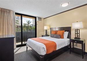 a hotel room with a large bed and a large window at Castle Bamboo Waikiki Hotel in Honolulu