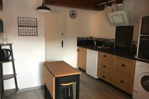 - une cuisine avec un comptoir, un évier et une table dans l'établissement Studio de la Tour des rondes - tout confort plein-centre, à Lavaur