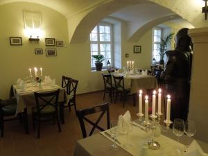 ein Zimmer mit Tischen und Kerzen in einem Restaurant in der Unterkunft Hotel Mutiger Ritter in Bad Kösen