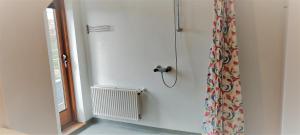 a bathroom with a shower curtain and a window at Feriehus Thy - I hjertet af Thy in Thisted