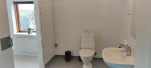 a white bathroom with a toilet and a sink at Feriehus Thy - I hjertet af Thy in Thisted