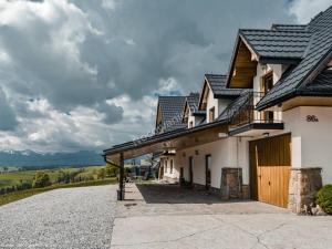 Una casa con un gran camino de entrada al frente. en Villa Julia - apartamenty widokowe, en Biały Dunajec