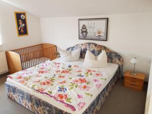 ein Schlafzimmer mit einem großen Bett mit einer Blumendecke in der Unterkunft Ferienwohnungen Sansibar in Kasnevitz