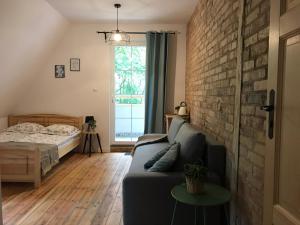 a living room with a couch and a brick wall at Widokówka in Łagów